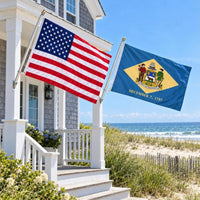 American flag and Delaware State Flag flying side by side outdoors