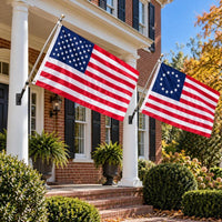 American flag and Betsy Ross flag flying side by side outdoors