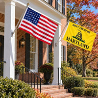 American flag and Don't Tread on Maryland flag flying side by side outdoors