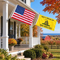 American flag and Don't Tread on Michigan flag flying side by side outdoors